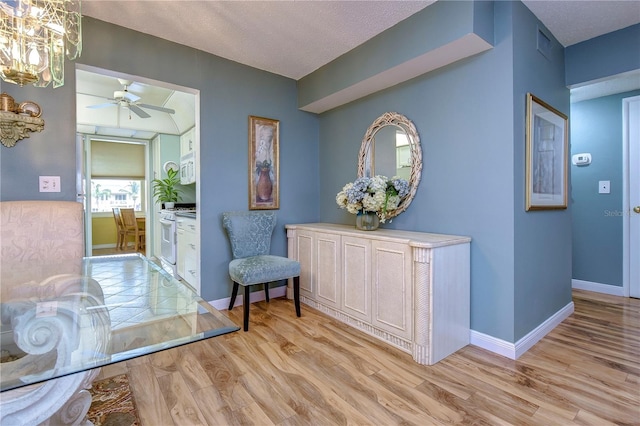 interior space with a textured ceiling, light hardwood / wood-style flooring, and a chandelier