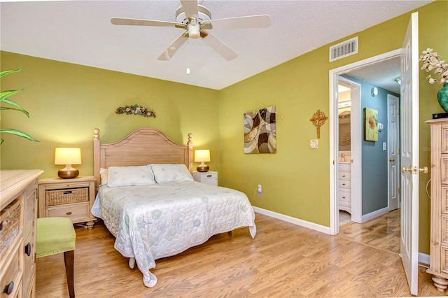 bedroom with light wood-type flooring, ensuite bathroom, and ceiling fan