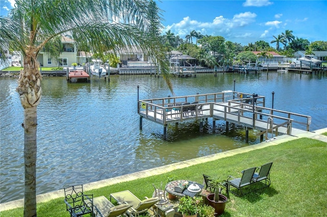 view of dock with a water view and a yard