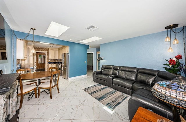 living room featuring a skylight and light tile patterned floors