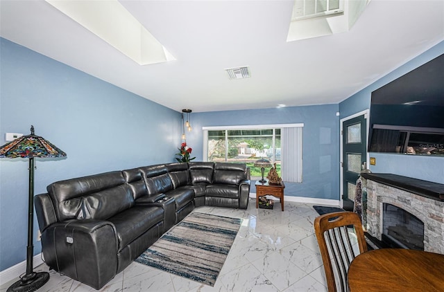 living room featuring a skylight, a fireplace, and light tile patterned flooring