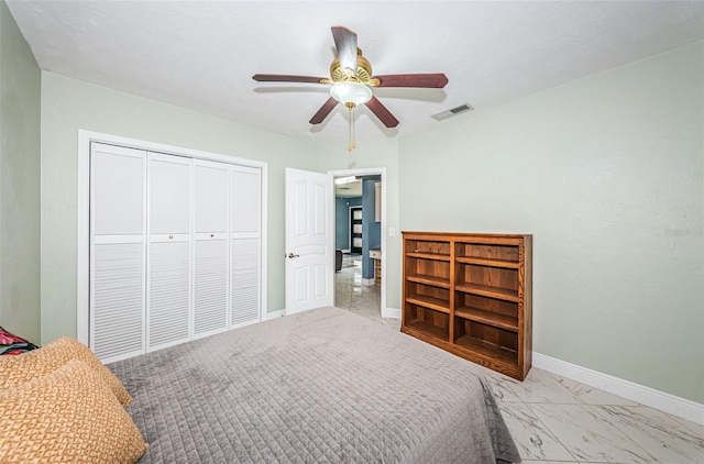 bedroom featuring light tile patterned floors, ceiling fan, and a closet