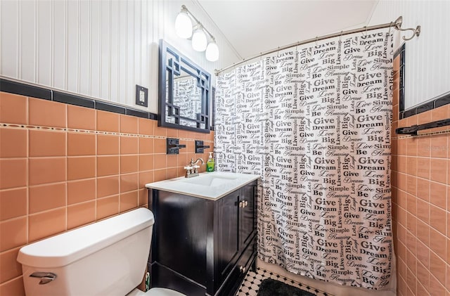 bathroom with tile walls, toilet, and vanity