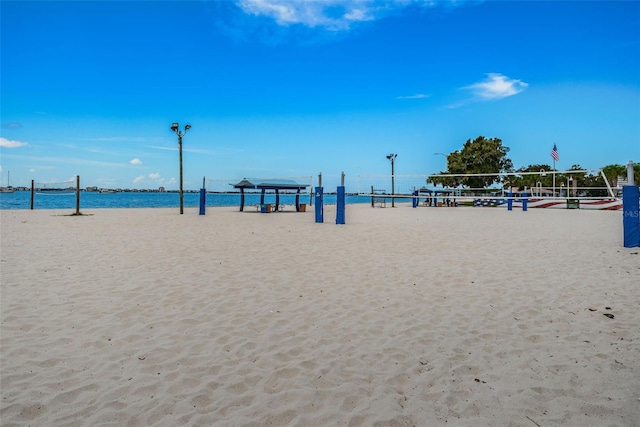 view of home's community featuring volleyball court, a beach view, and a water view