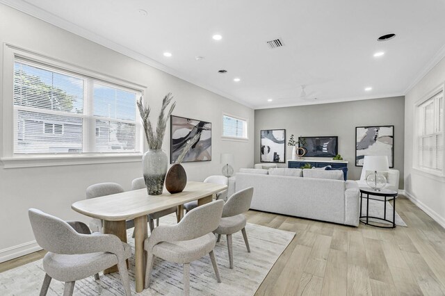 dining area featuring plenty of natural light, crown molding, and light hardwood / wood-style flooring