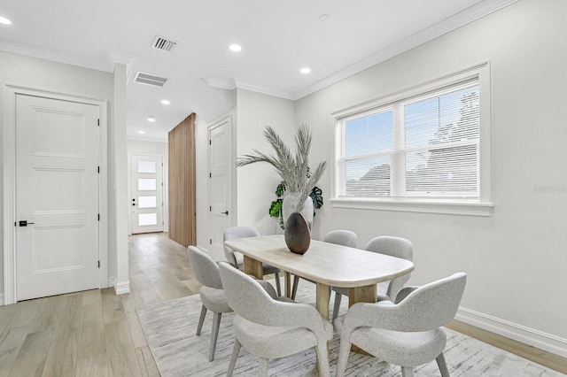 dining room featuring light hardwood / wood-style floors and ornamental molding