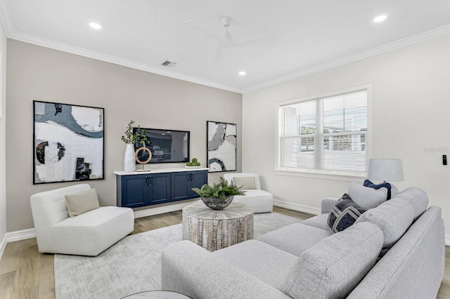 living room featuring ceiling fan, light hardwood / wood-style floors, and crown molding