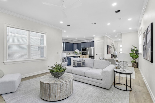 living room with plenty of natural light, light wood-style flooring, crown molding, and recessed lighting