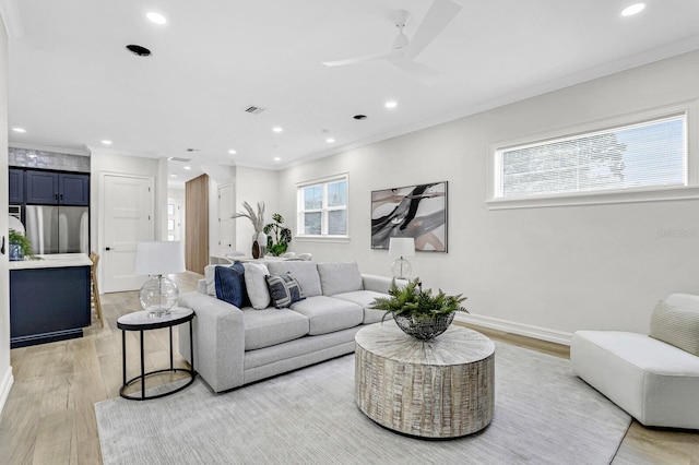 living room with crown molding, light hardwood / wood-style flooring, and ceiling fan