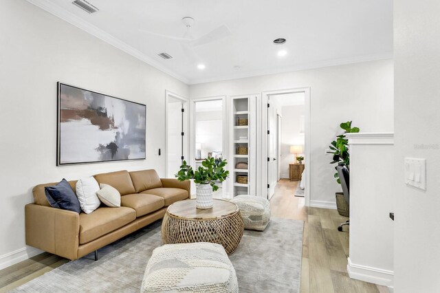 living room with light wood-type flooring and ornamental molding