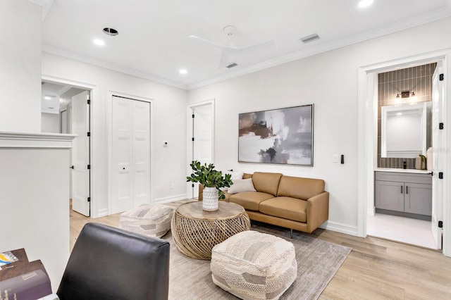 living area with visible vents, baseboards, light wood-style flooring, ornamental molding, and recessed lighting