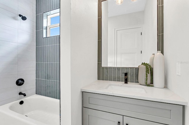 bathroom with tiled shower / bath combo and vanity