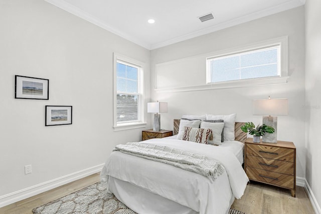 bedroom featuring light hardwood / wood-style floors and crown molding