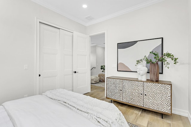 bedroom with hardwood / wood-style floors, a closet, and ornamental molding