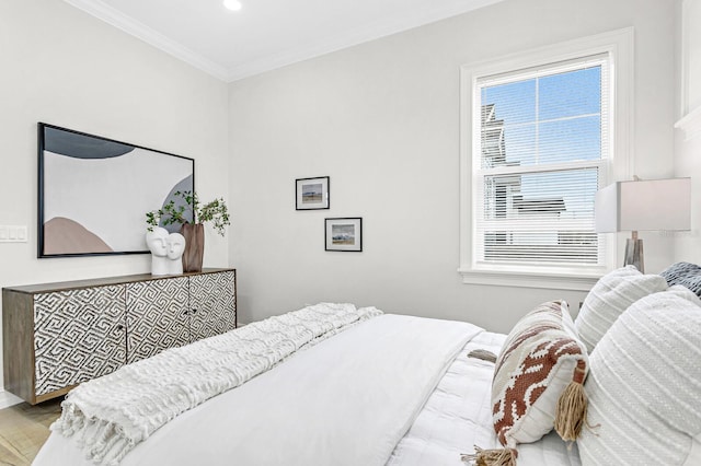 bedroom featuring crown molding and light hardwood / wood-style flooring