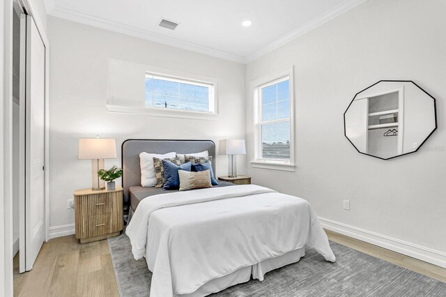 bedroom with crown molding and hardwood / wood-style floors