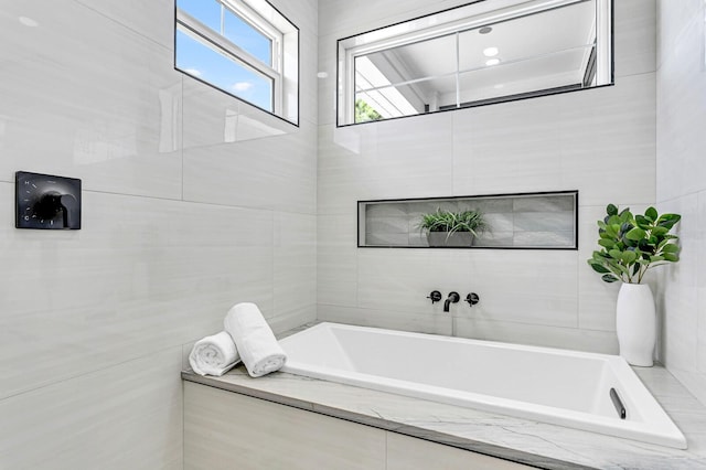 bathroom with a relaxing tiled tub