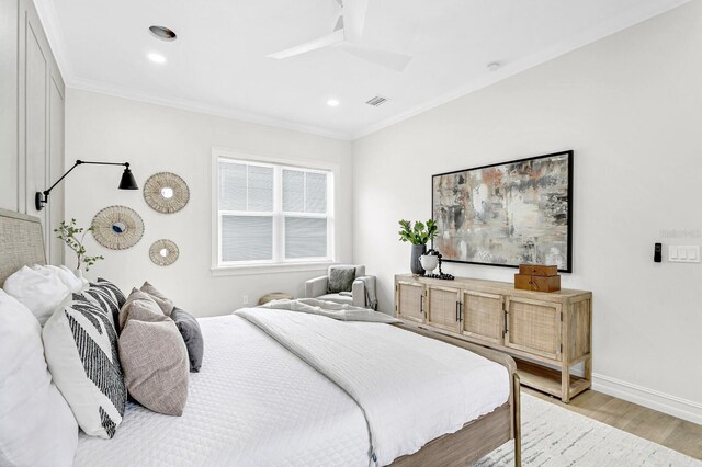 bedroom with ceiling fan, ornamental molding, and light hardwood / wood-style flooring