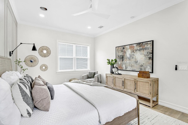 bedroom featuring ornamental molding, visible vents, light wood-style flooring, and baseboards