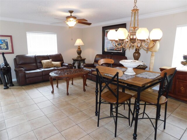 dining space with crown molding, ceiling fan with notable chandelier, and light tile patterned floors