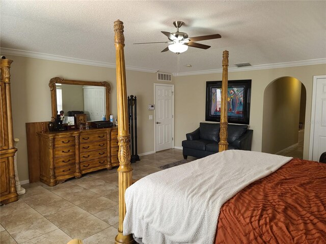 bedroom featuring ceiling fan, a textured ceiling, light tile patterned flooring, and ornamental molding