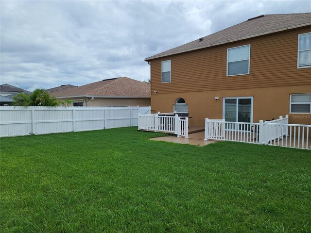 rear view of property with a lawn and a patio