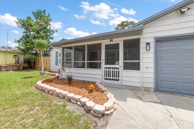 view of front of home featuring a sunroom, a garage, and a front lawn