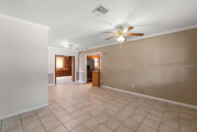 tiled empty room with ceiling fan and ornamental molding