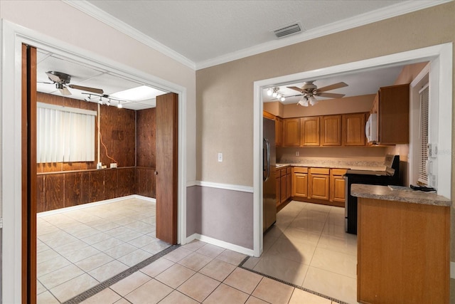 kitchen with light tile patterned floors, track lighting, ceiling fan, range with electric stovetop, and crown molding