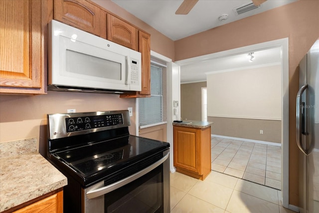 kitchen featuring ceiling fan, appliances with stainless steel finishes, light tile patterned flooring, and ornamental molding