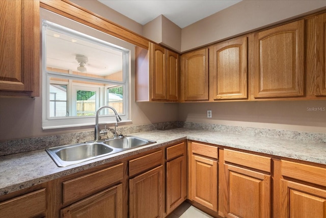 kitchen with brown cabinets, light countertops, and a sink