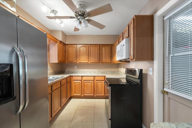 kitchen featuring light tile patterned flooring, sink, appliances with stainless steel finishes, track lighting, and ceiling fan