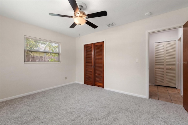 unfurnished bedroom with ceiling fan, light colored carpet, and a closet