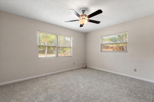 unfurnished room with a healthy amount of sunlight, carpet, and baseboards