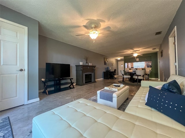 living room featuring ceiling fan and a textured ceiling