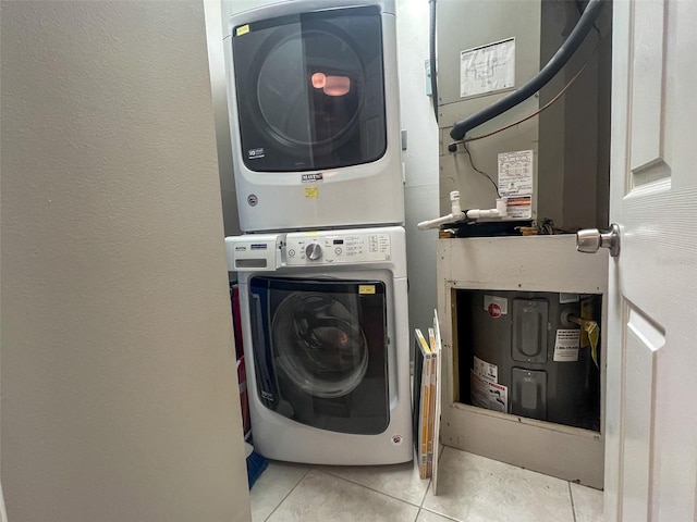 washroom featuring stacked washer / drying machine and light tile patterned floors