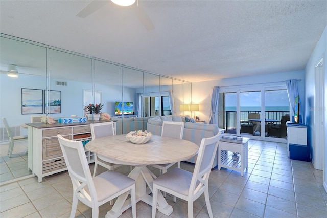 dining room featuring ceiling fan, a textured ceiling, light tile patterned flooring, and visible vents