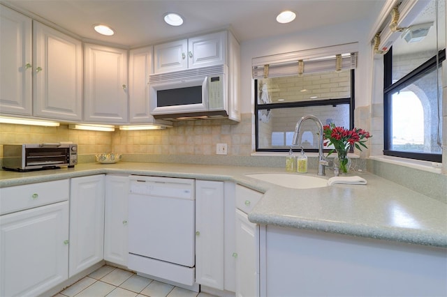 kitchen featuring white appliances, a toaster, a sink, and white cabinetry