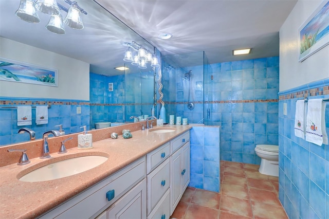 full bathroom featuring tile patterned flooring, a sink, tile walls, and toilet