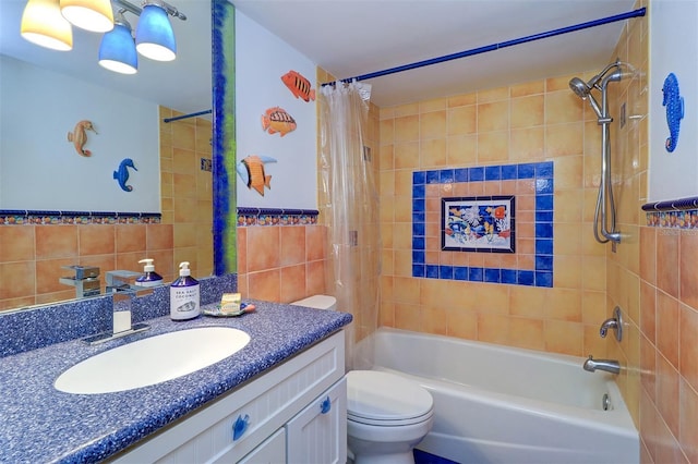 bathroom with tile walls, shower / bathtub combination with curtain, toilet, wainscoting, and vanity