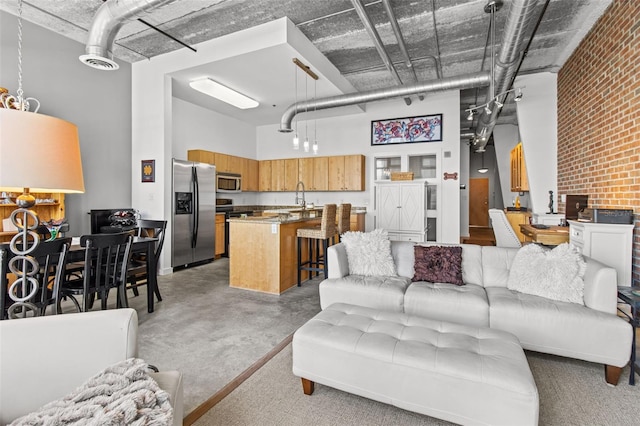 living room with sink, brick wall, and a towering ceiling