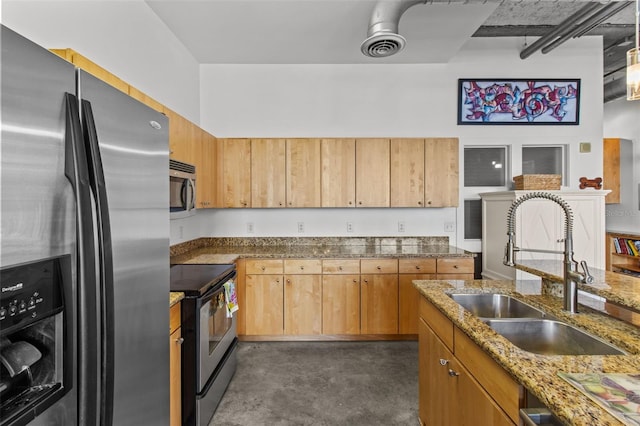 kitchen featuring stainless steel appliances, light stone counters, and sink