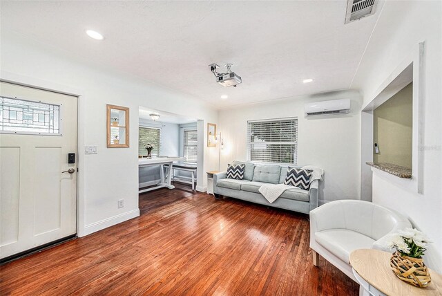 living room featuring a wall mounted AC and hardwood / wood-style floors