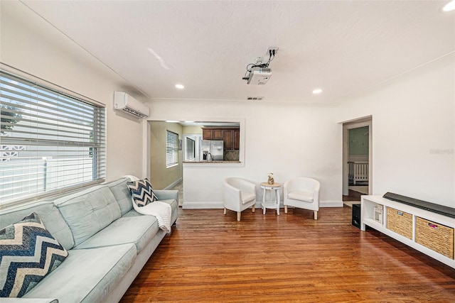 living room with recessed lighting, visible vents, wood finished floors, and an AC wall unit