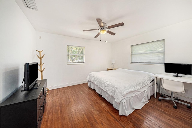 bedroom featuring a ceiling fan, dark wood finished floors, visible vents, and baseboards