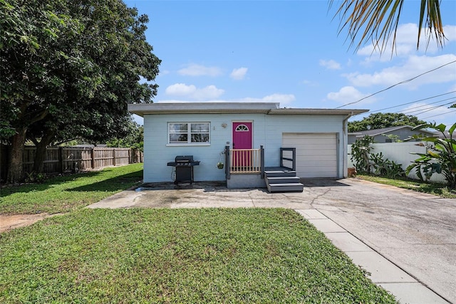 ranch-style home with a garage, a front yard, concrete driveway, and fence