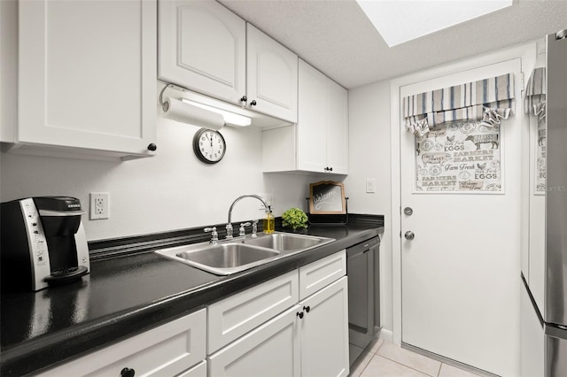 kitchen featuring appliances with stainless steel finishes, white cabinetry, light tile patterned floors, and sink