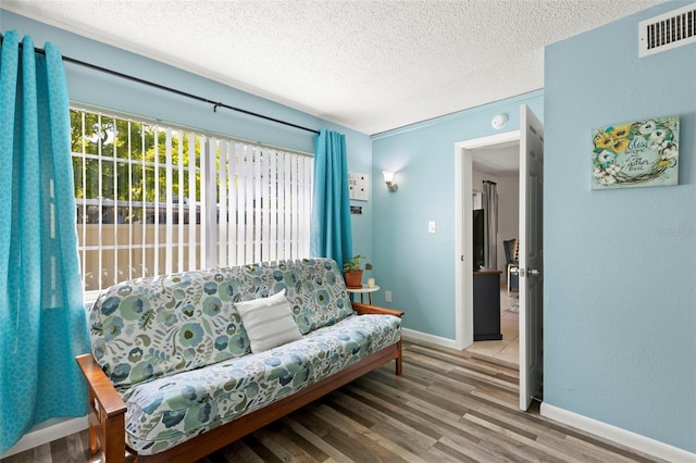 living area with a textured ceiling and hardwood / wood-style flooring