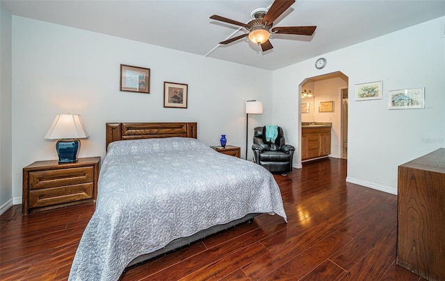 bedroom featuring ceiling fan, dark hardwood / wood-style flooring, and ensuite bath