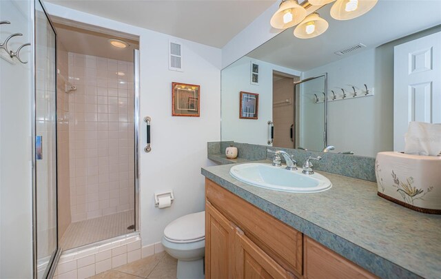 bathroom featuring tile patterned floors, vanity, walk in shower, and toilet